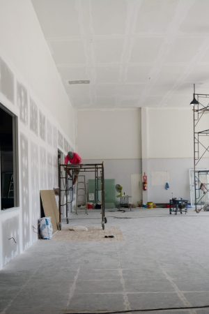 the iron scaffoldings on tile ground and the black lamp on  the ceiling with the labor while  renovation  the old office